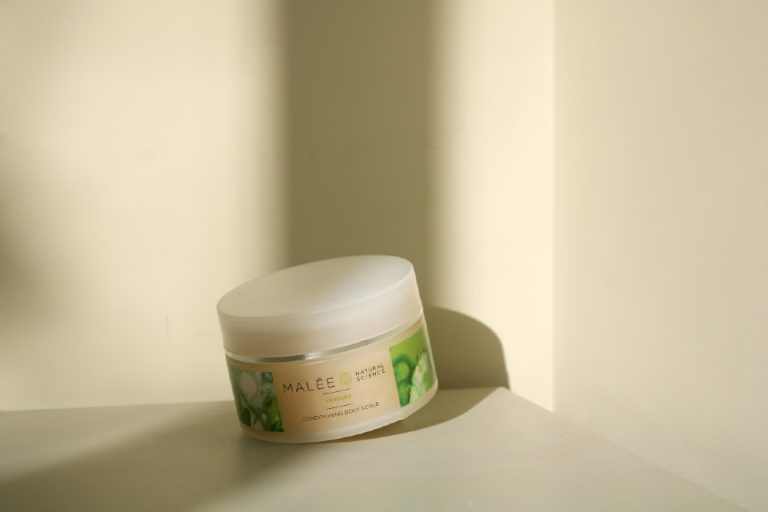 Malée Natural Science 220g Verdure Conditioning Body Scrub placed on a table with beige and cream background