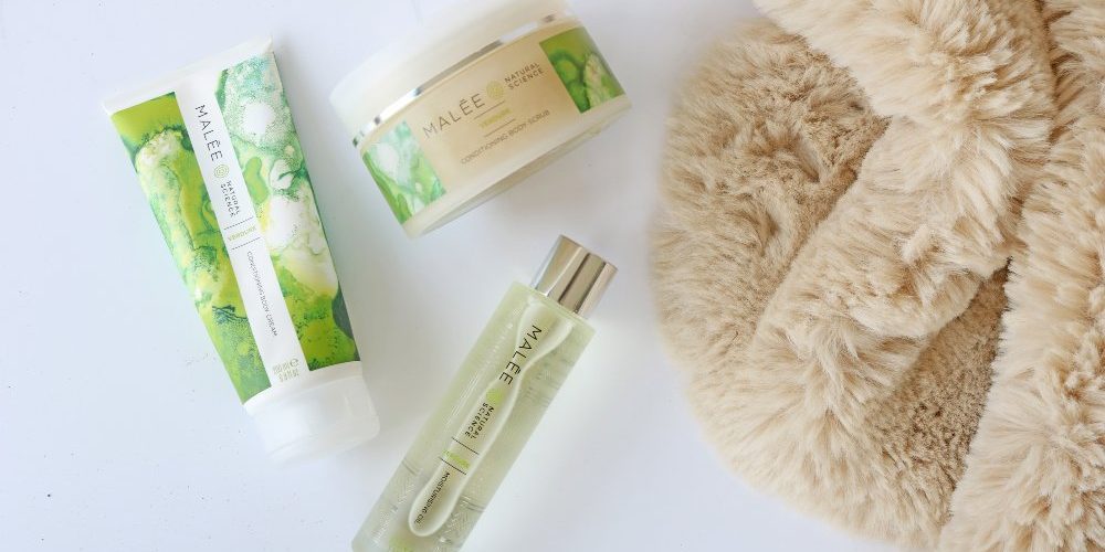 Self-care-tip-Malée-Natural-Science Self-care tip Malée Natural Science 200ml Verdure Conditioning Body Cream 220ml Verdure Conditioning Body Scrub 100ml Verdure Moisturising Body Oil set next to a clear brown fur