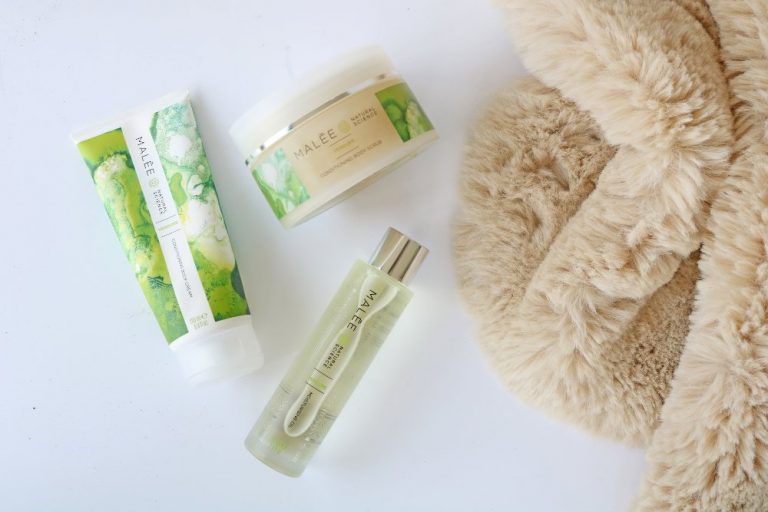 Self-care tip Malée Natural Science 200ml Verdure Conditioning Body Cream 220ml Verdure Conditioning Body Scrub 100ml Verdure Moisturising Body Oil set next to a clear brown fur