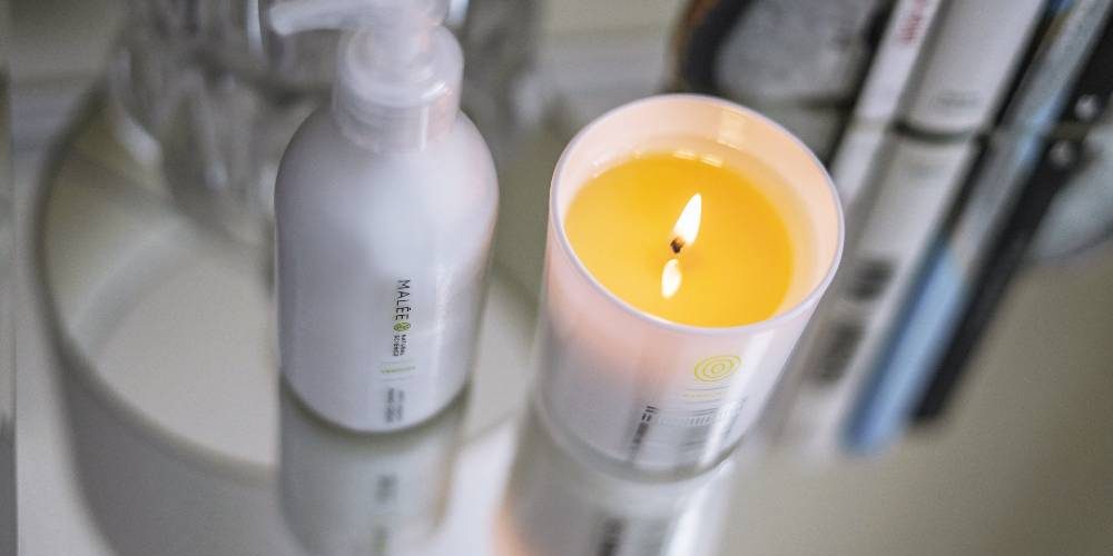 Natural-Skincare-products-Malée-Natural-Science Natural Skincare Products Malée Natural Science On a clear night table, are set a lighted 220ml Verdure soybean candle and a 200ml Glass Anti Ageing Hand Cream