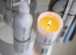 Natural Skincare Products Malée Natural Science On a clear night table, are set a lighted 220ml Verdure soybean candle and a 200ml Glass Anti Ageing Hand Cream