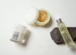 Self-Care Checklist Malee Natural Science With a white background, Malee 100ml Verdure body oil is et on a Dark grey stone, next to it an open 250ml body scrub and a 220ml Peppersage Soy Candle