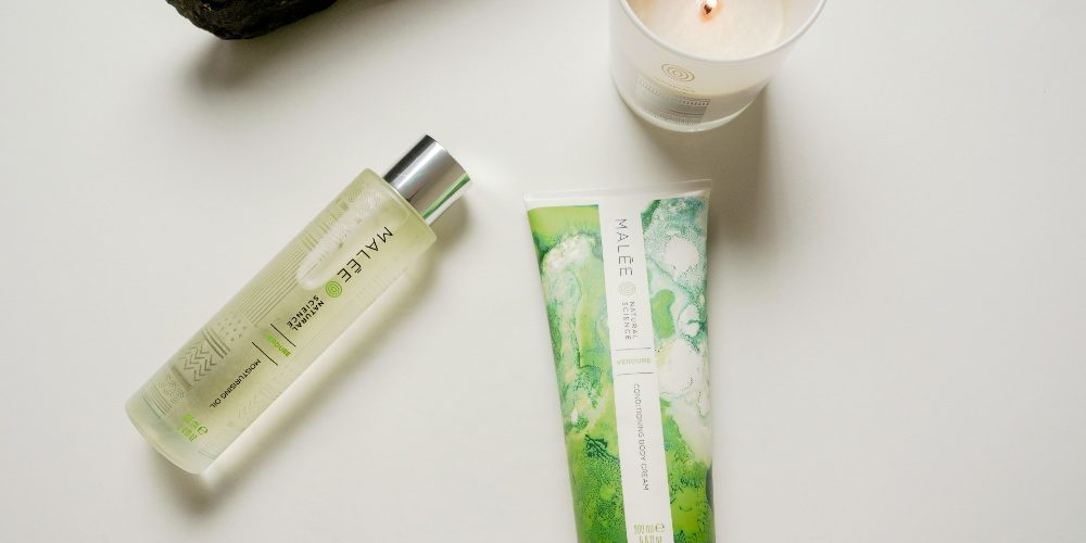 Dry-Skin-Rash-Malee-Natural-Science Dry Skin Rash Malee Natural Science set on a white platform, a lighted 220ml soy candle 100ml Moisturising Body Oil 200ml Conditioning Body Cream