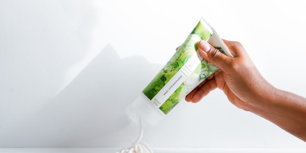 Dry Skin Patches Malee Natural Science, A female hand squeezing some cream out of the 200ml Verdure Conditioning Body Cream