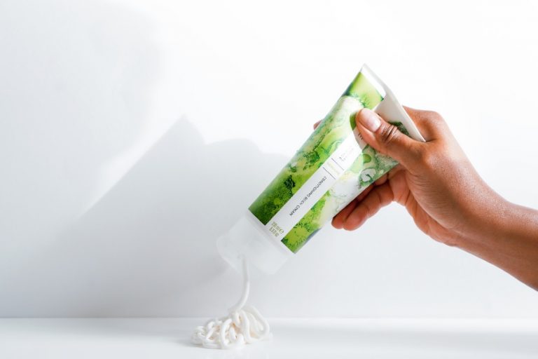 Dry Skin Patches Malee Natural Science, A female hand squeezing some cream out of the 200ml Verdure Conditioning Body Cream