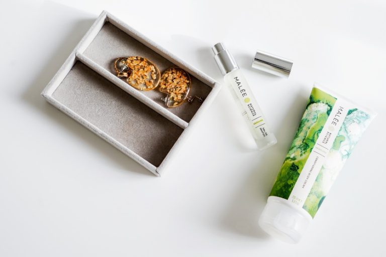 Is Luxury Skincare Worth it Malee natural Science On a white background, an opened 12ml Verdure Eau De Parfum, 200ml Verdure Conditioning Body Cream and a jewelry box containing golden earrings
