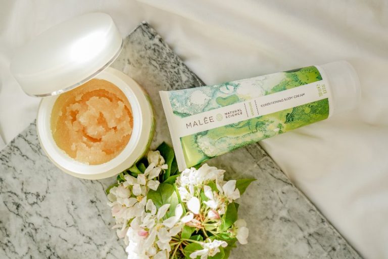 How to get Dye off skin Malee Natural Science. On a marbled table set next to a white linen, an opened 250ml Verdure Body Scrub, 200ml Verdure Conditioning Body Cream and a Jasmin bouquet