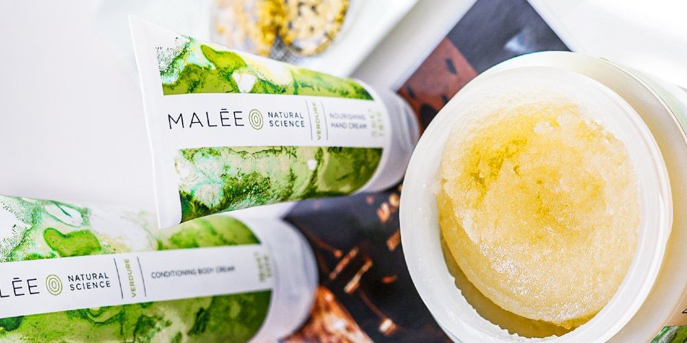 BHAs Malee Natural Science Set on a golden light book cover are the Malee 200ml verdure Conditioning Body Cream with the 75ml Nourishing Hand cream next by an open 250ml Conditioning Body scrub