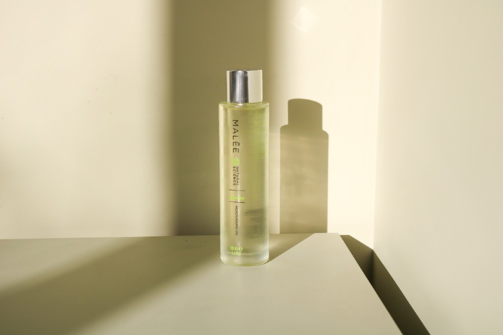 Malée Natural Science 100ml Verdure Moisturising Body Oil with its reflection on a table