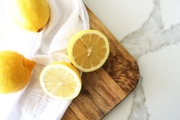 Malée Natural Science lemon aromatherapy benefits 2 whole lemons and 2 sliced lemons place on a wooden board covered with white sheet