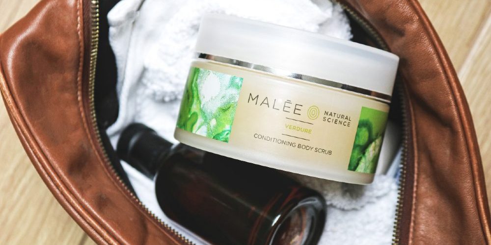 Men's Luxury Skincare Malee Natural Science Verdure Conditioning Scrub with white towel and an amber glass bottle in a brown bag