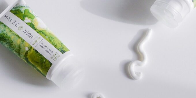 Best-Hand-Cream-For-Very-Dry-Skin-Malee Natural Science Best Hand Cream For Very Dry Skin Malee Natural Science On a pale grey background 2 x 75ml Verdure Nourishing Cream laid side by side a snake line has been drawn with cream in front of each tube.