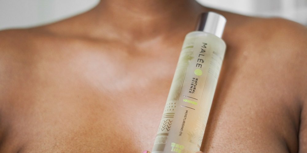 Mental Health Awareness Malee Natural Science A bare-chested African lady holding a Malee 100ml Moisturising body oil Glass bottle