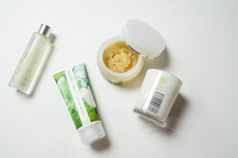 Skincare Ingredients To Avoid Malee natural Science On a white surface, an opened 250ml Malee Moisturising Body scrub, A 100ml Verdure Moisturising Body Oil and a 220ml 100% Verdure Soy Candle