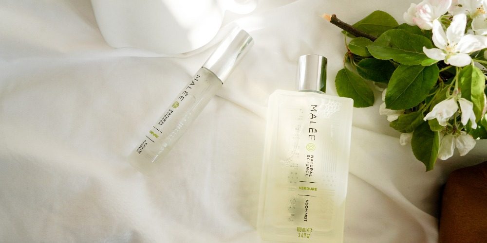 Christmas-Gifts-For-Friends-Malee-Natural-Science Christmas gifts for friends Malee natural Science On a white linen, a bouquet of Jasmine flowers sets next to a 100ml verdure room Mist and 12ml Verdure Eau de Parfum