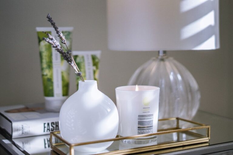 8 Beauty Routines- Malee Natural Science, on a night table, 200ml Verdure Conditioning Body Cream and 75ml Nourishing Hand Cream are set on a book, next a night light and a golden tray with a lighted 220ml verdure Soy Candle and a white ceramic flowers pot with some lavenders